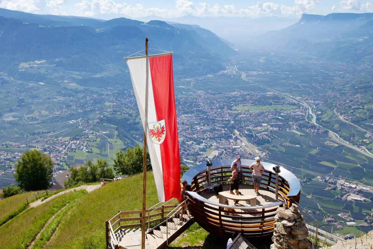 Panoramic view of Merano from vantage point, Süd Tirol flag in foreground