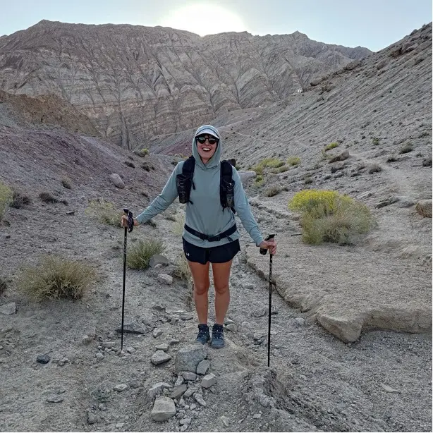 Women standing in mountains with hiking poles