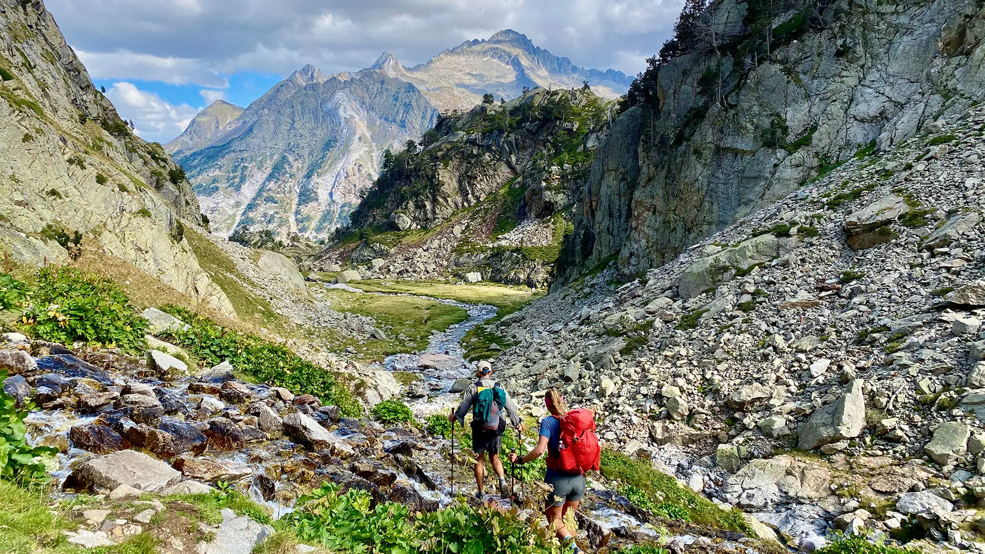 Two hikers walking on mountain path in the Pyrenees mountains