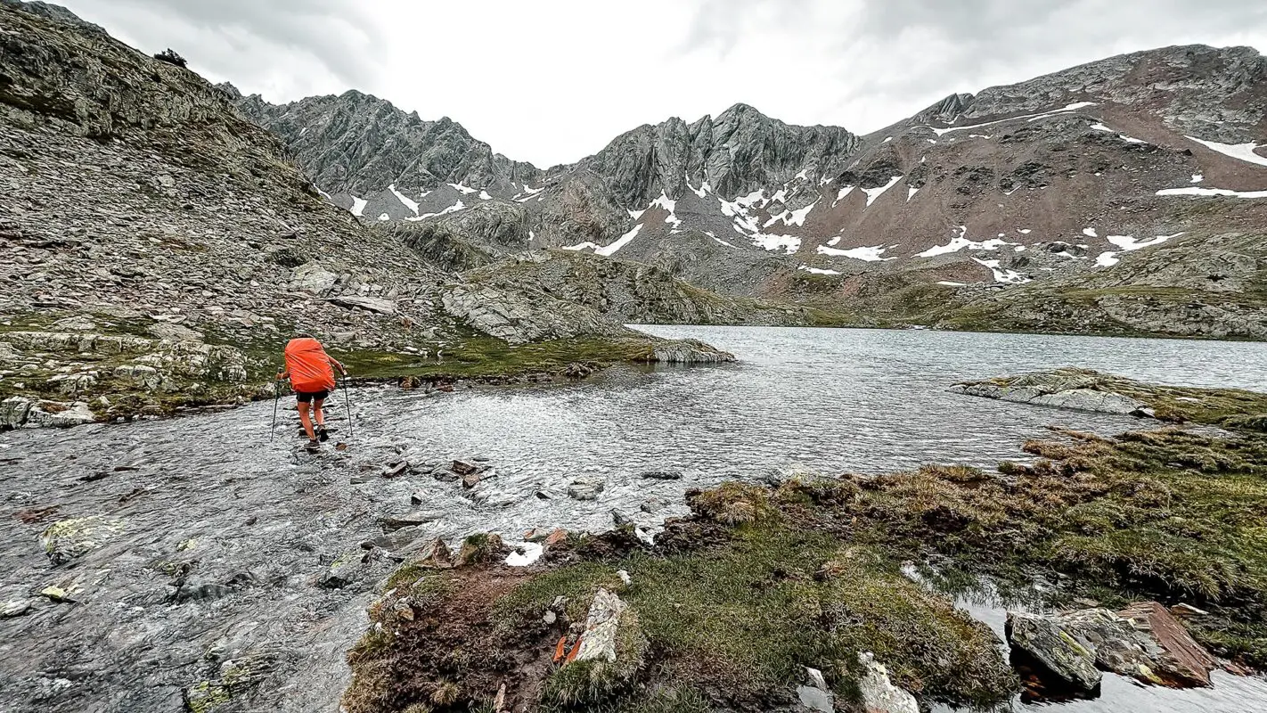 Women crossing a small river in Pyrenees mountains