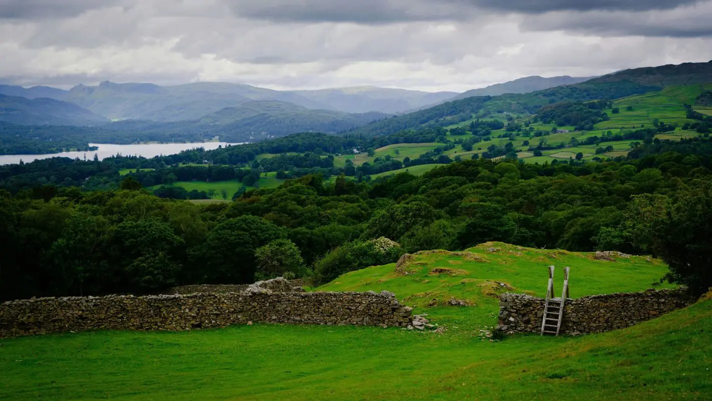 Green fields in English countryside with stone wall in foreground