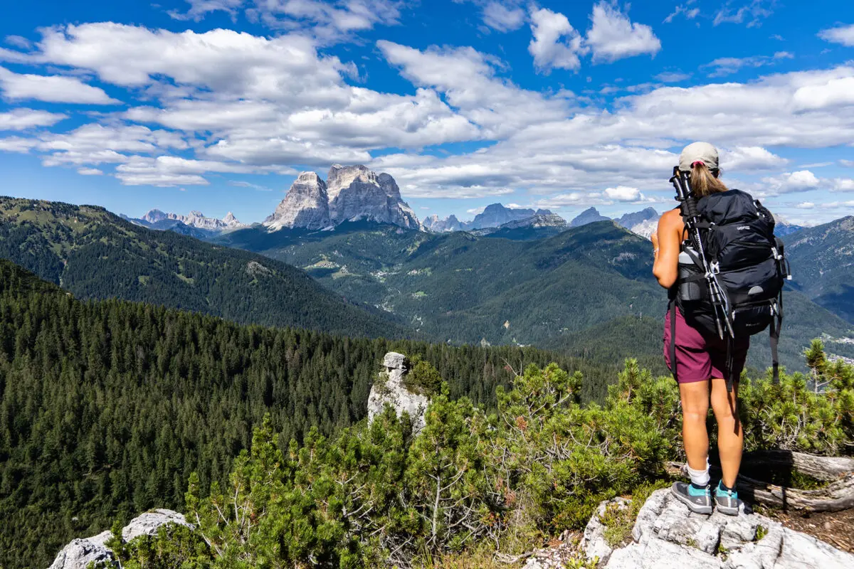 Hiker watching out in the distance over green valley and mountains