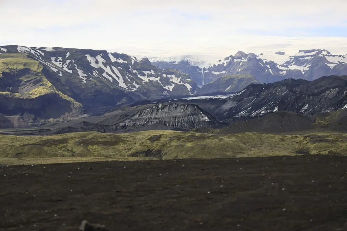 snow covered peaks with green landscape