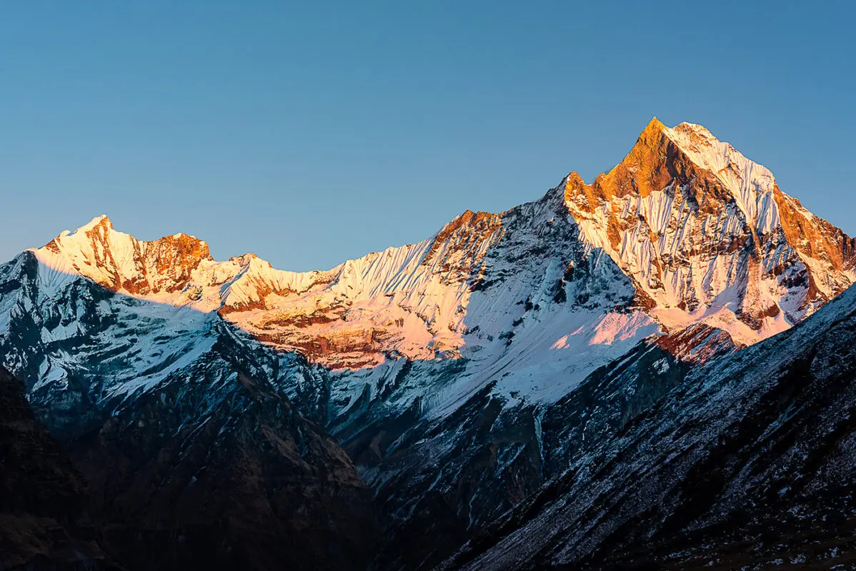 Top of rugged and snow covered mountain peak