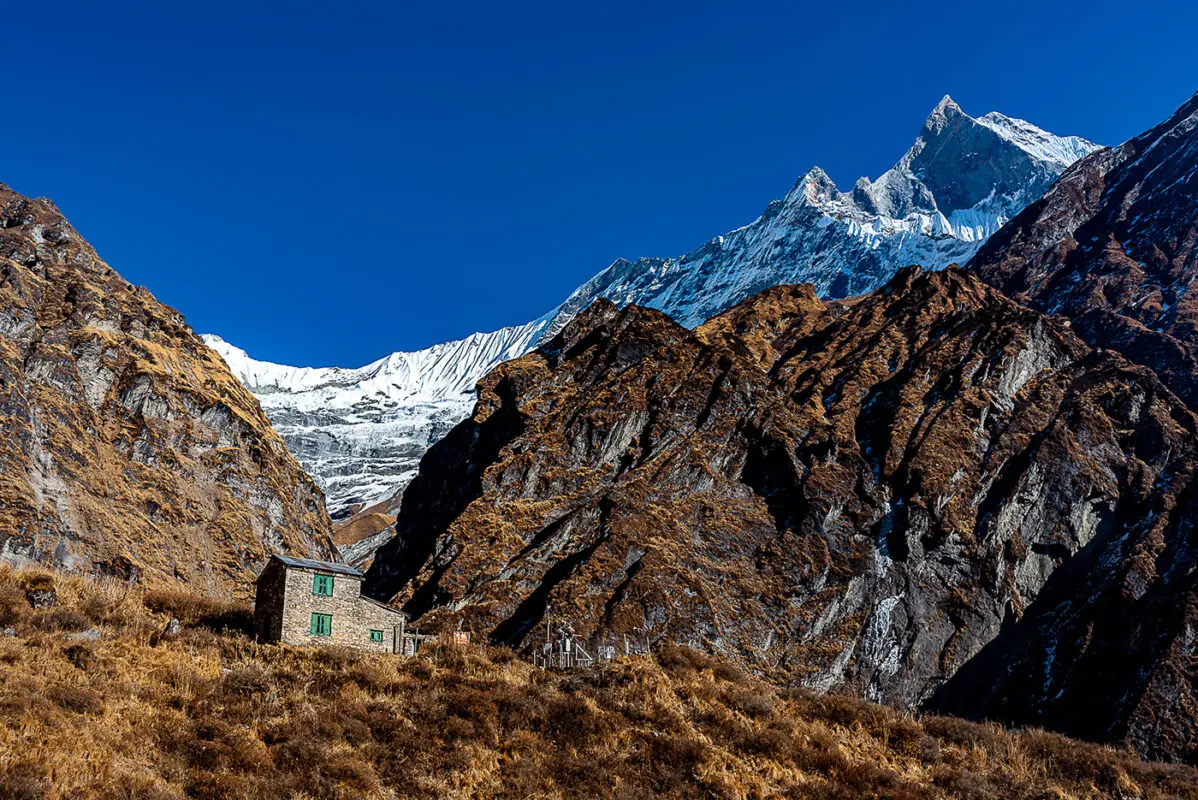 small stone hut with mountains in background