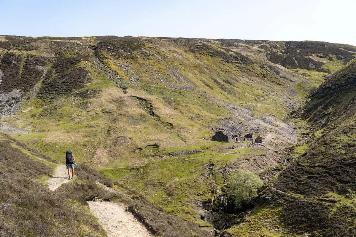 person hiking towards old ruins