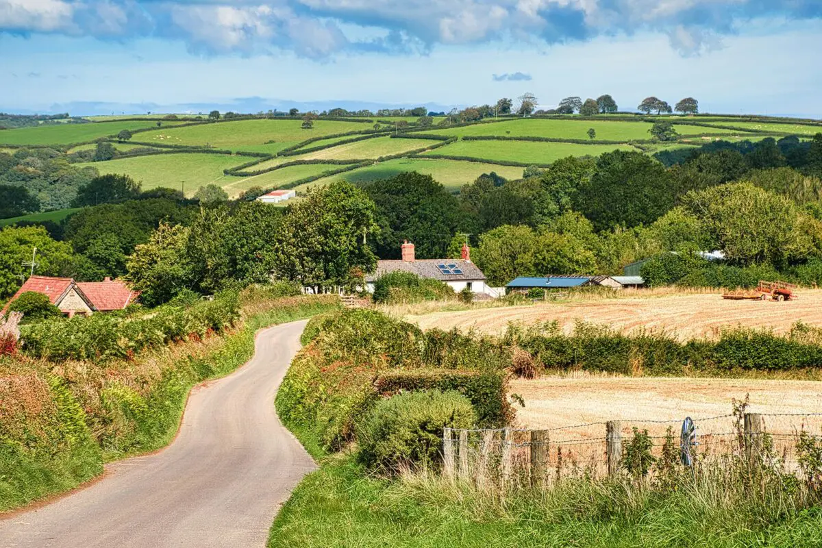 Road leading to small town in countryside with green hills