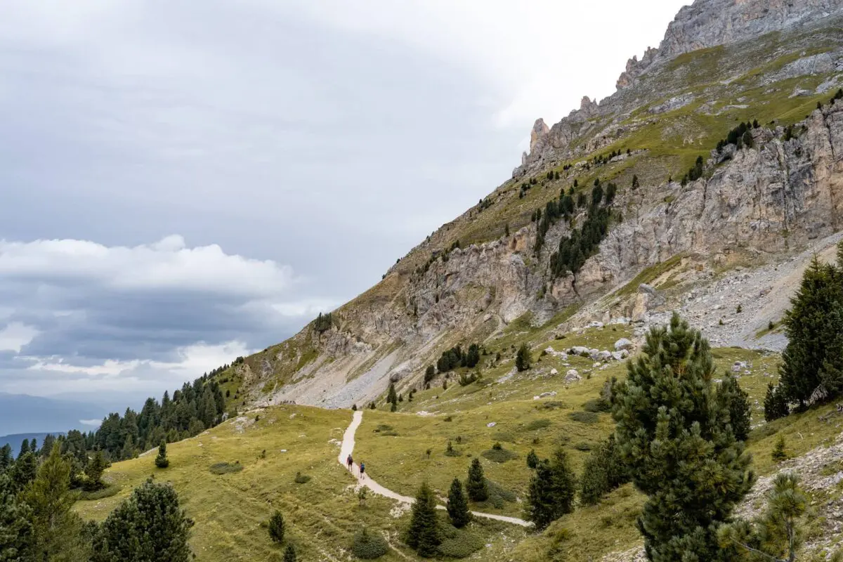 two persons hiking on hiking trail near mountain