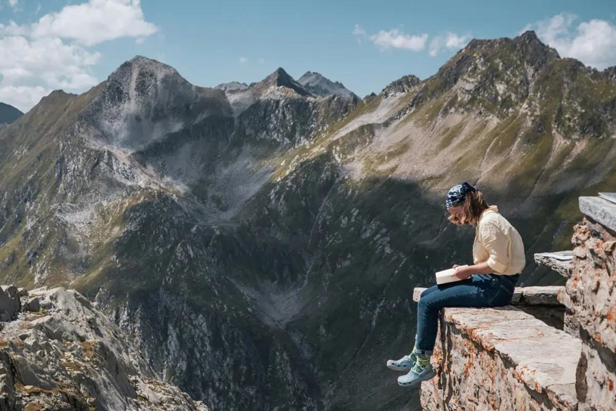 women reading with mountains in background