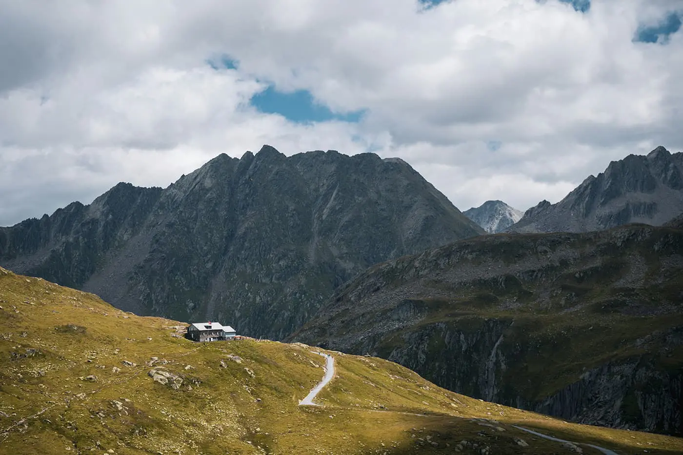 mountain hut with rugged peaks in the background