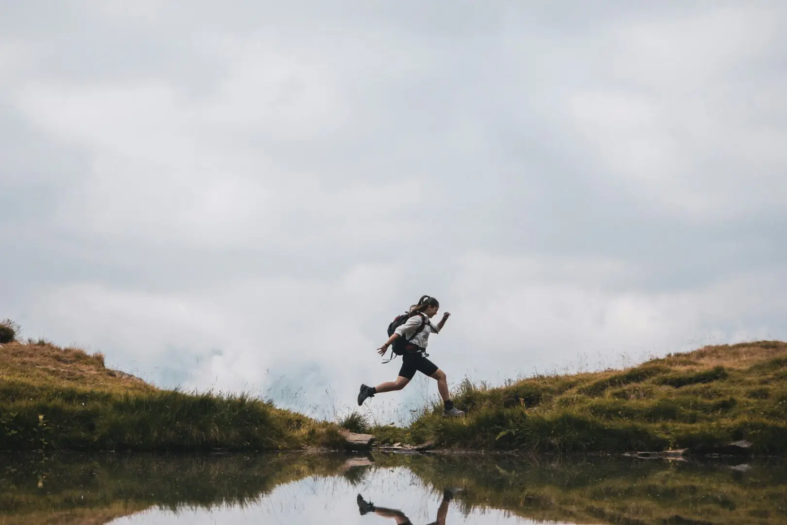 women jumping near body of water