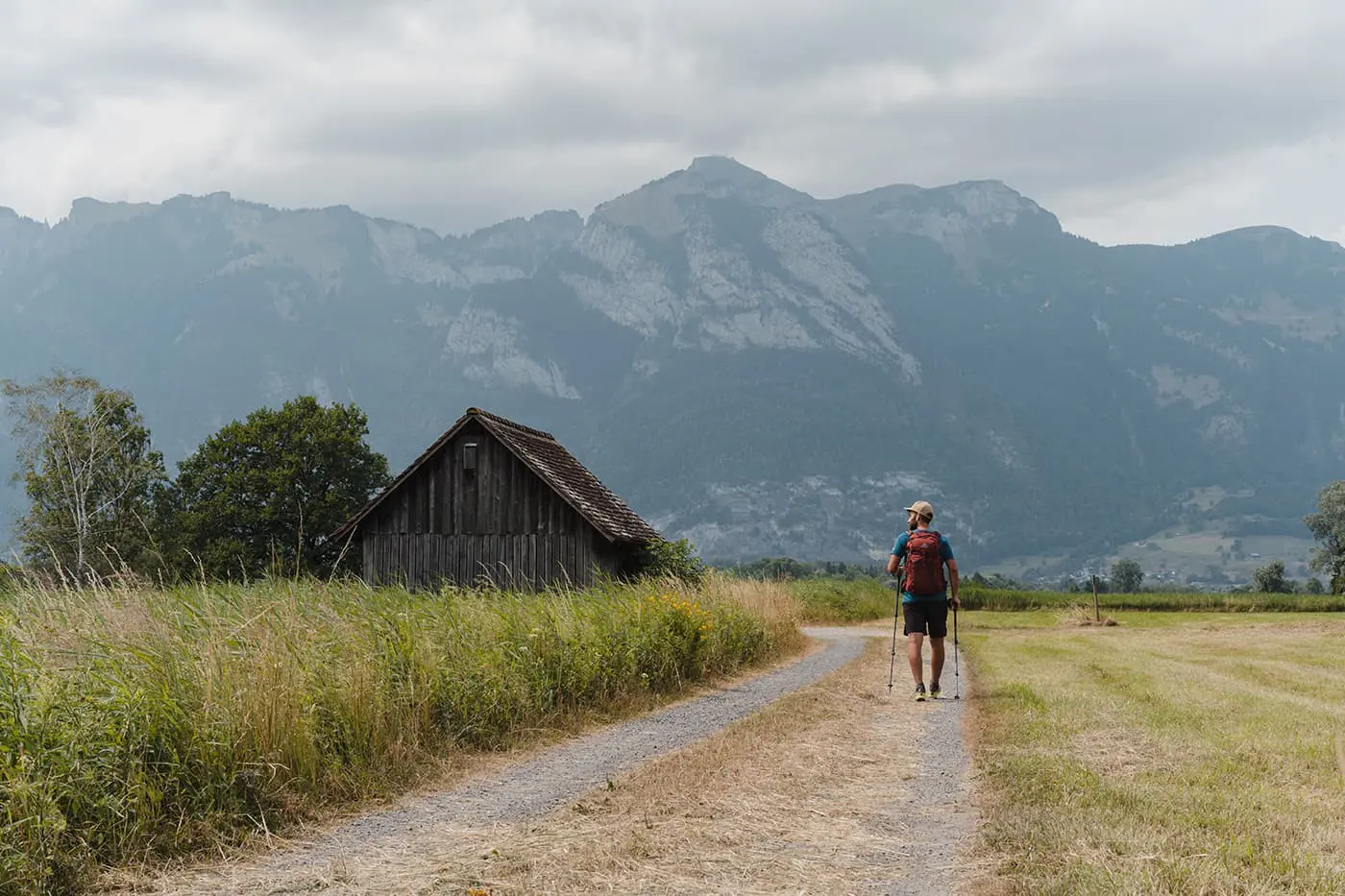 man hiking on unpaved path in green landscape