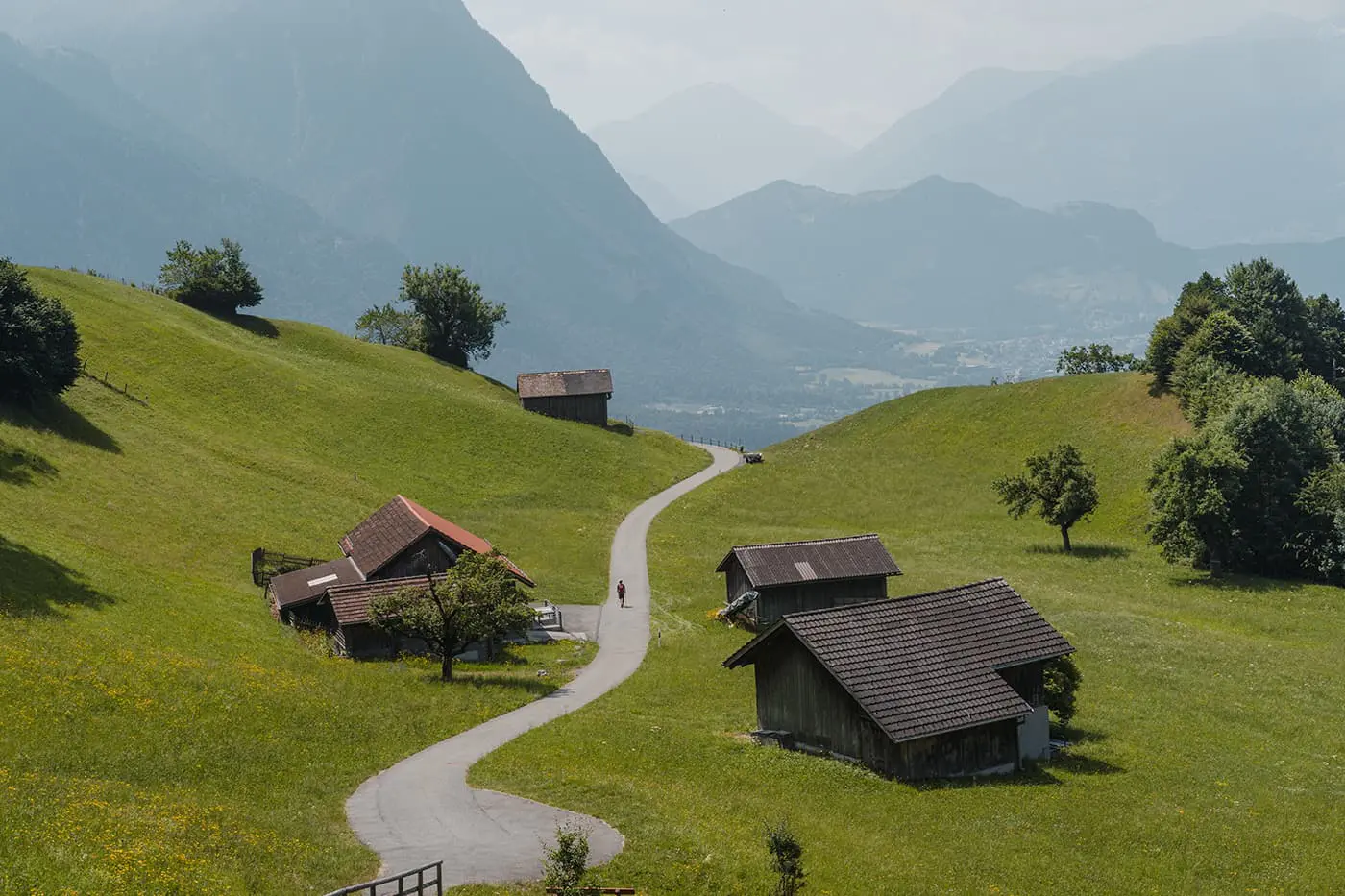 man hiking on road between some small houses