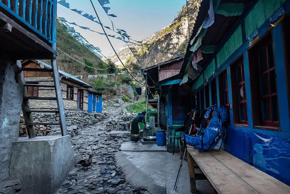 backpacks on wooden bench near small building