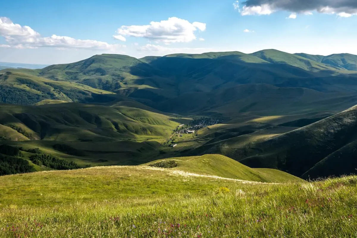 Green fields and mountains with small town in the valley