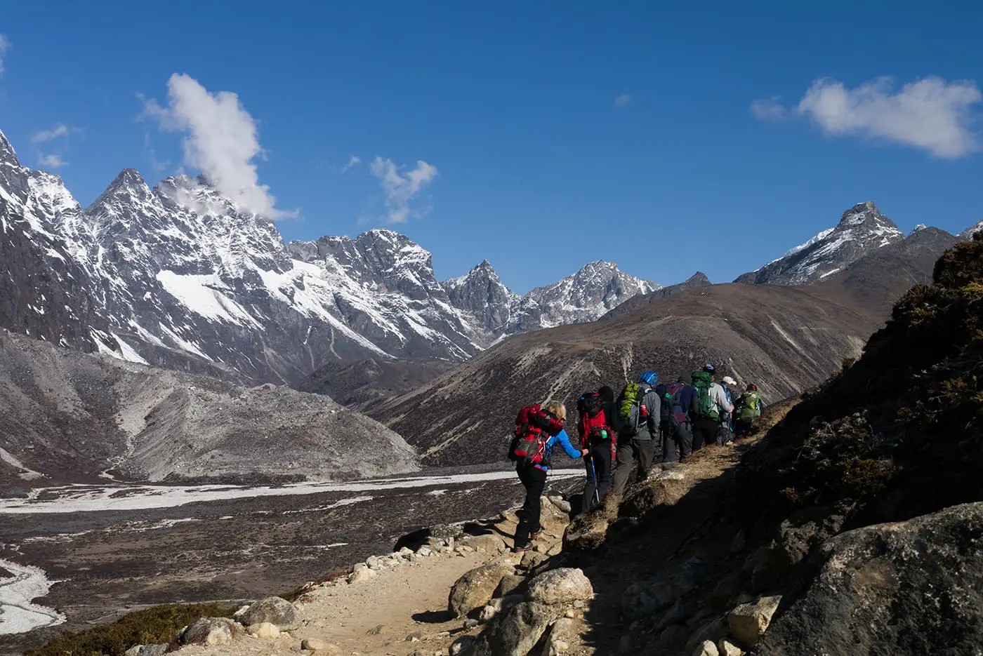 people hiking on small mountain trail