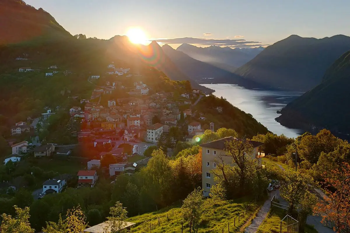 sun rising above the mountains near small town