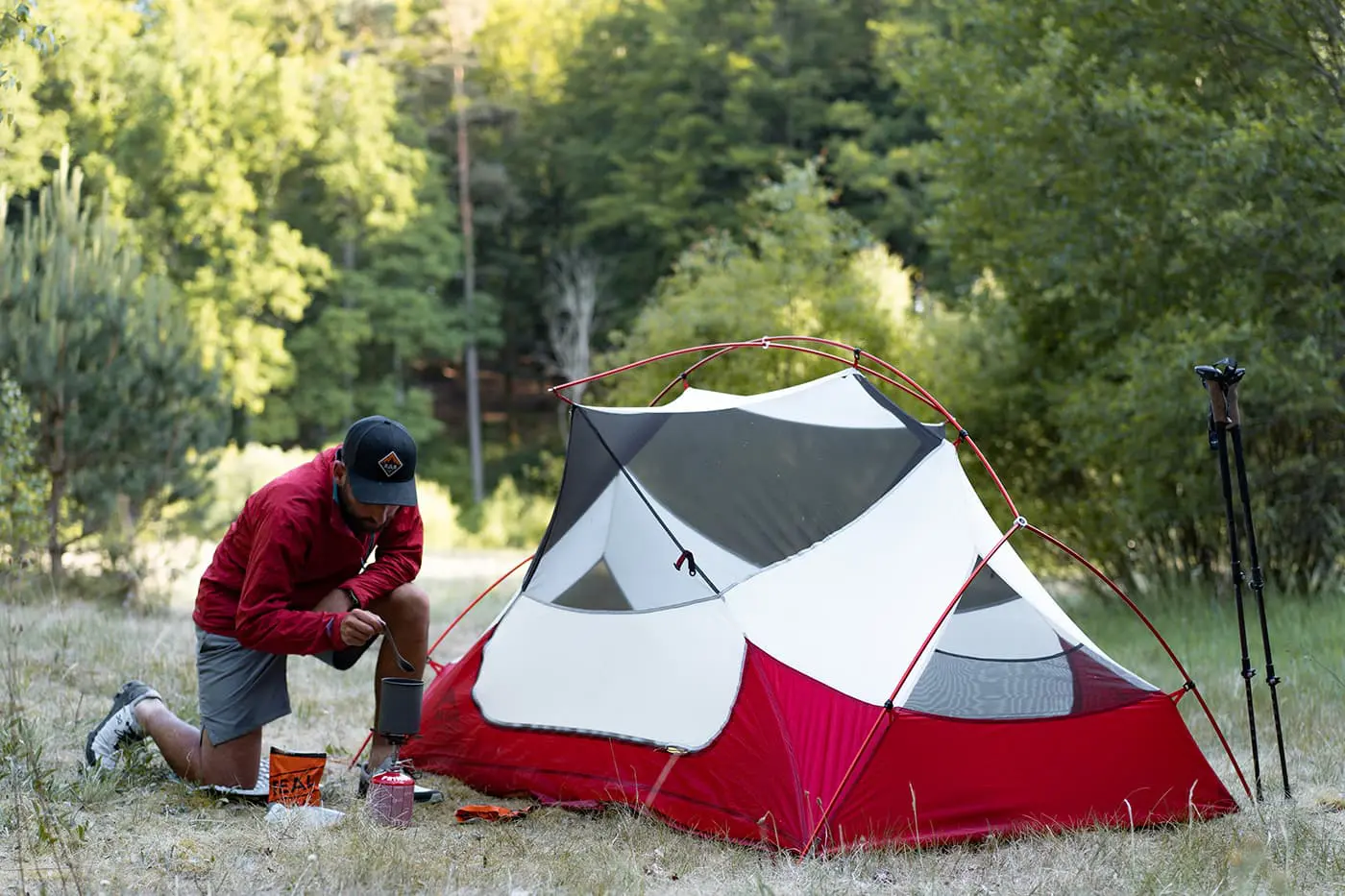 man making food by his tent in the outdoors