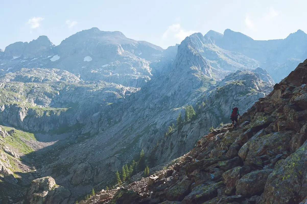 person walking in the mountains on rocky surface