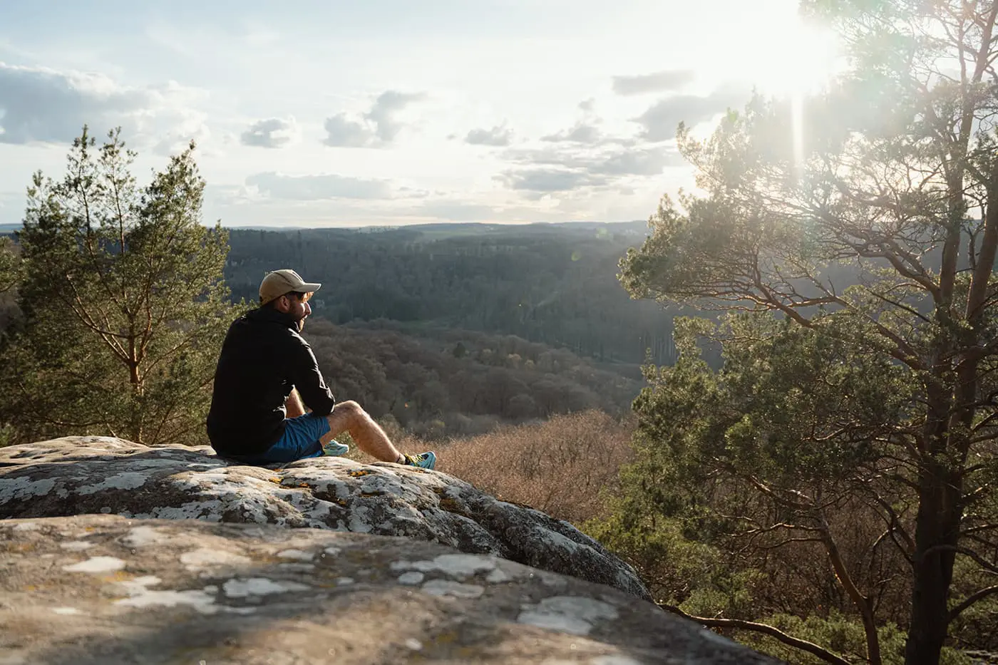 man sitting on rock on vantage point