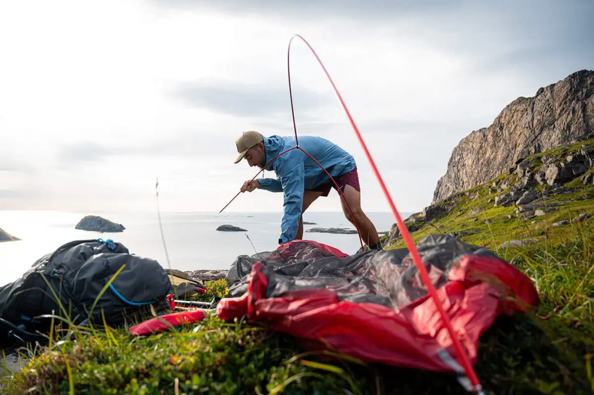 person setting up his tent for camping