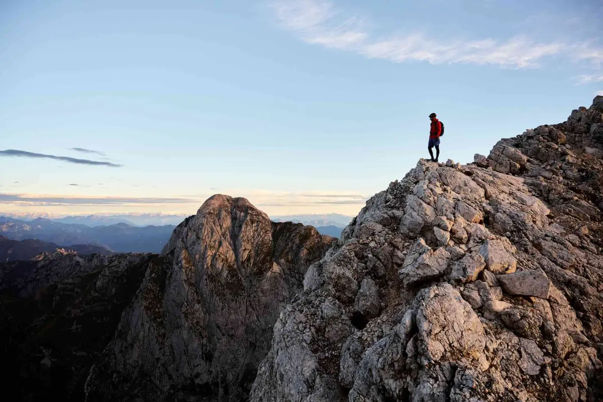 man looking out over rugged mountain peaks