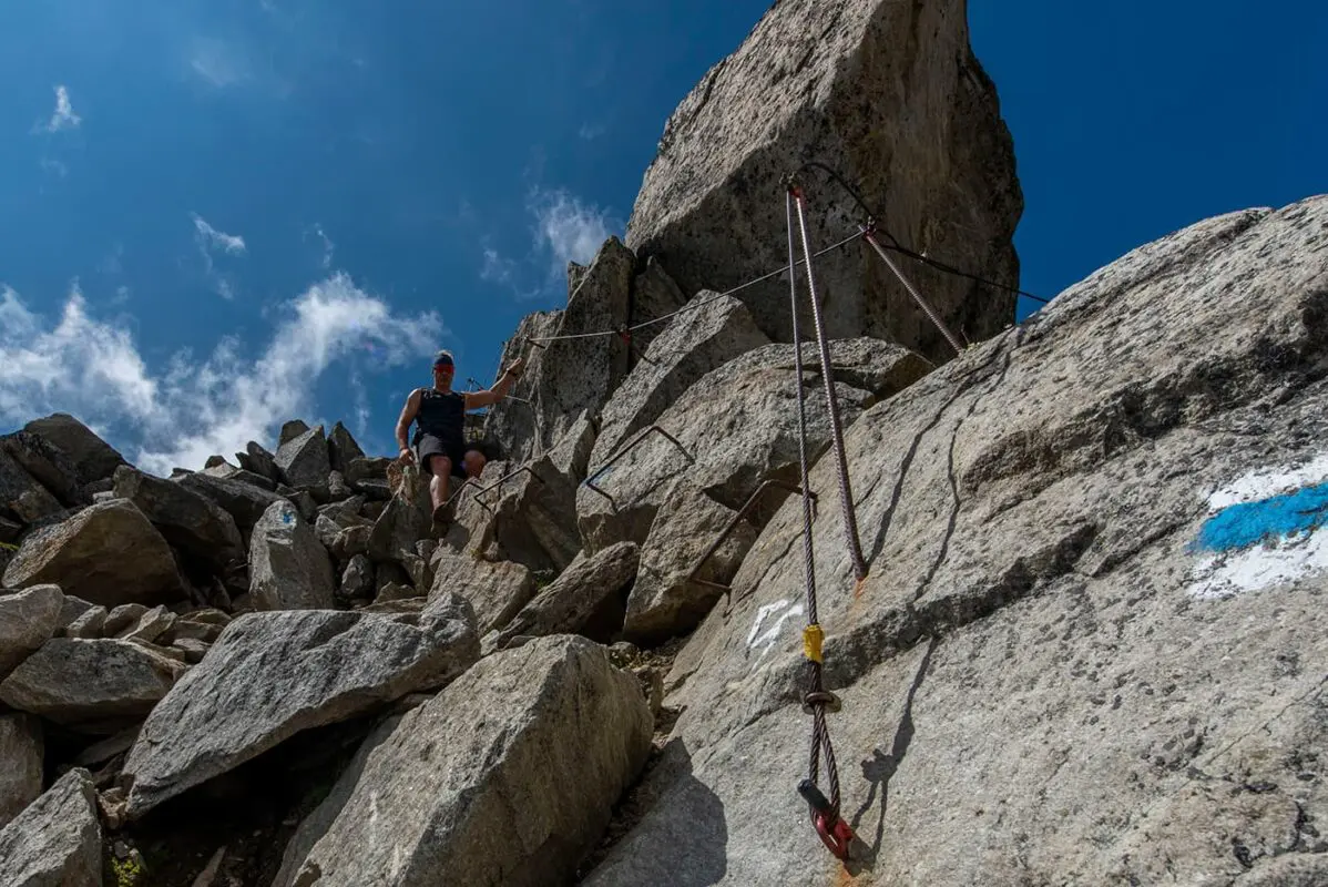 man hiking down difficult mountain path