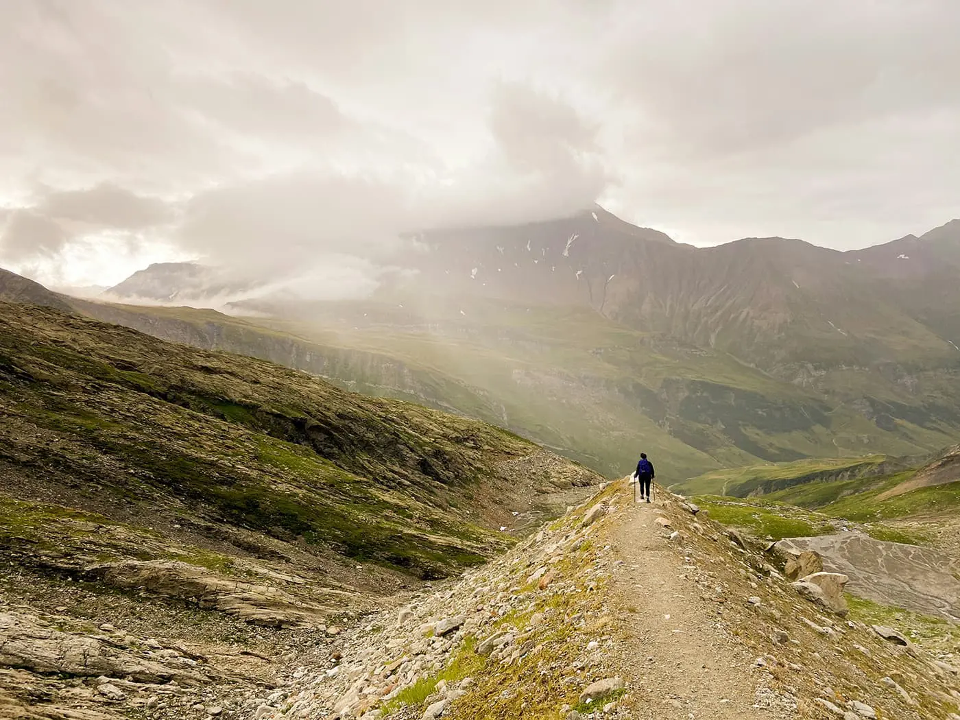 person hiking down mountain path