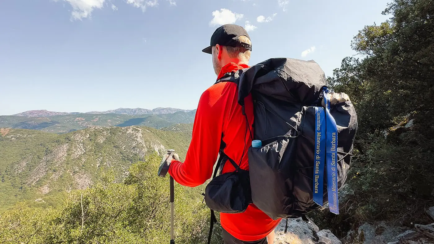 man with backpack looking out over mountains