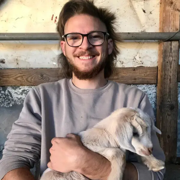 man holding baby goat