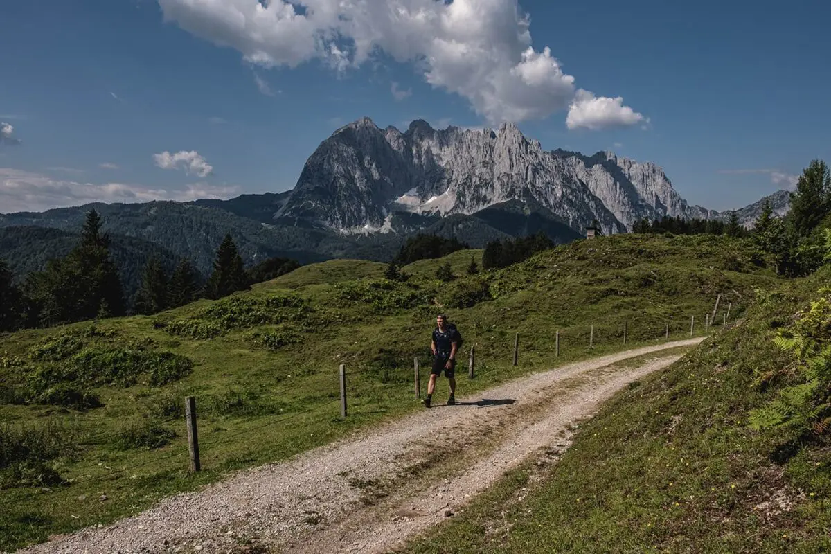 man hiking on unpaved pathway in mountain area