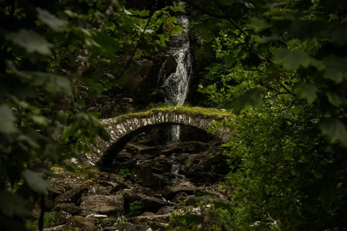 stone bridge behind waterfall