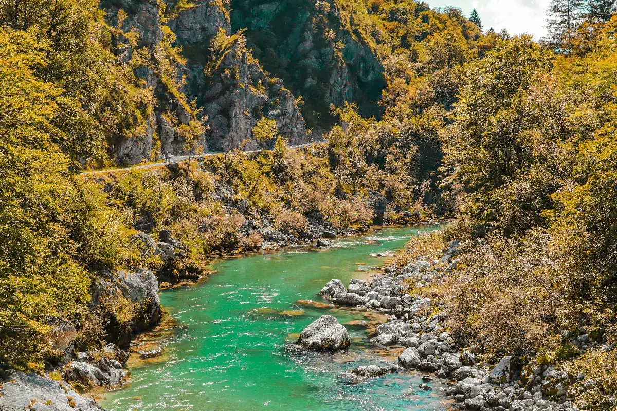 Turquoise blue river surrounded by forested rock faces