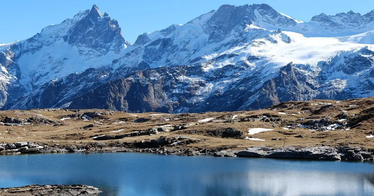 Alpine lake with snowcapped peaks in the background on the HexaTrek