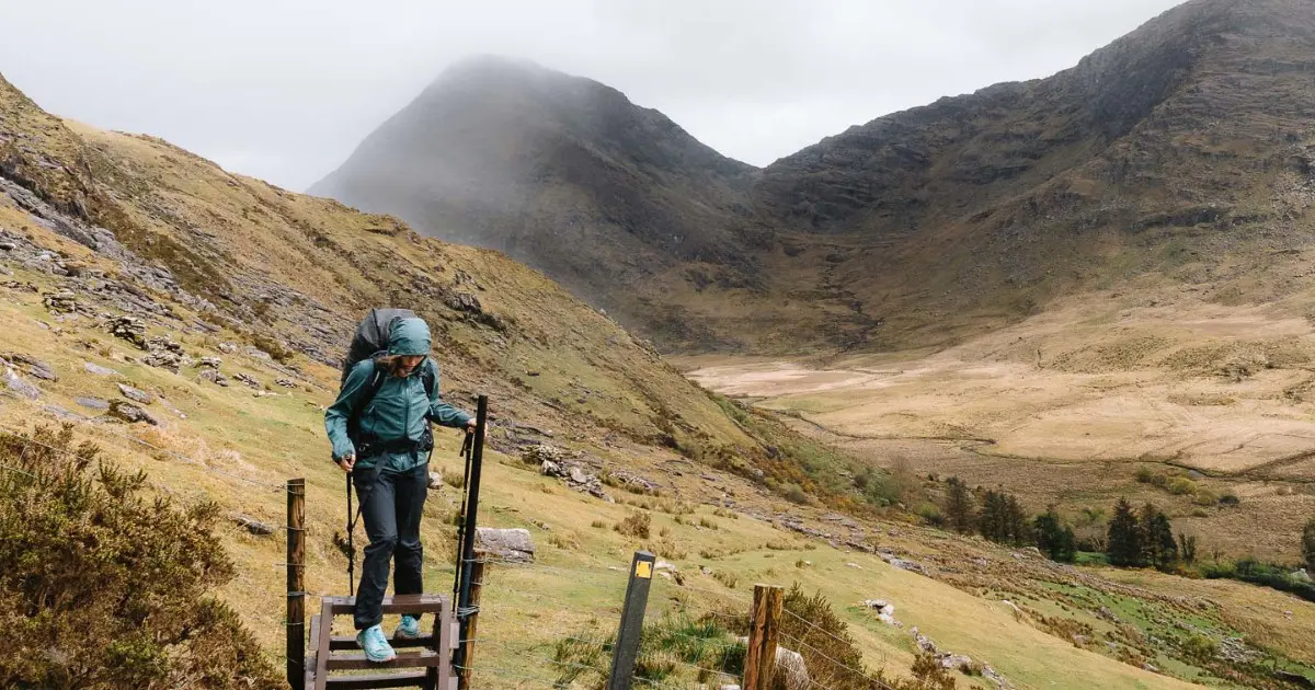 Woman climbing a wooden ladder on the Kerry Way