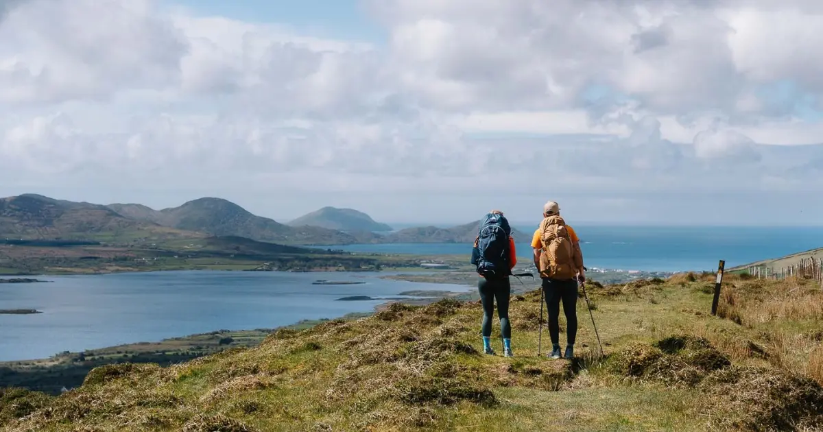 Two people on a hill looking over lakes