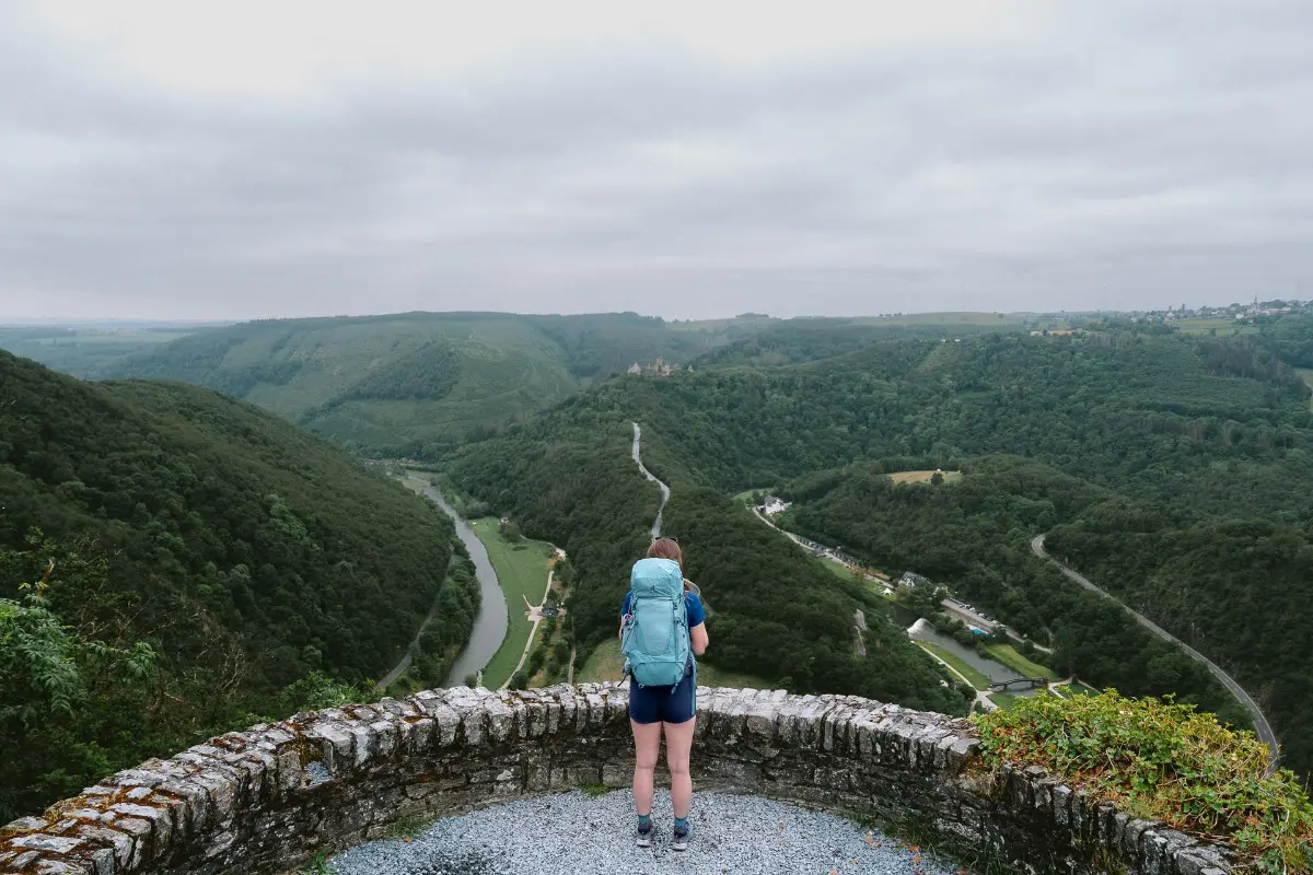 A woman standing on a viewpoint looking over the Lee Trail