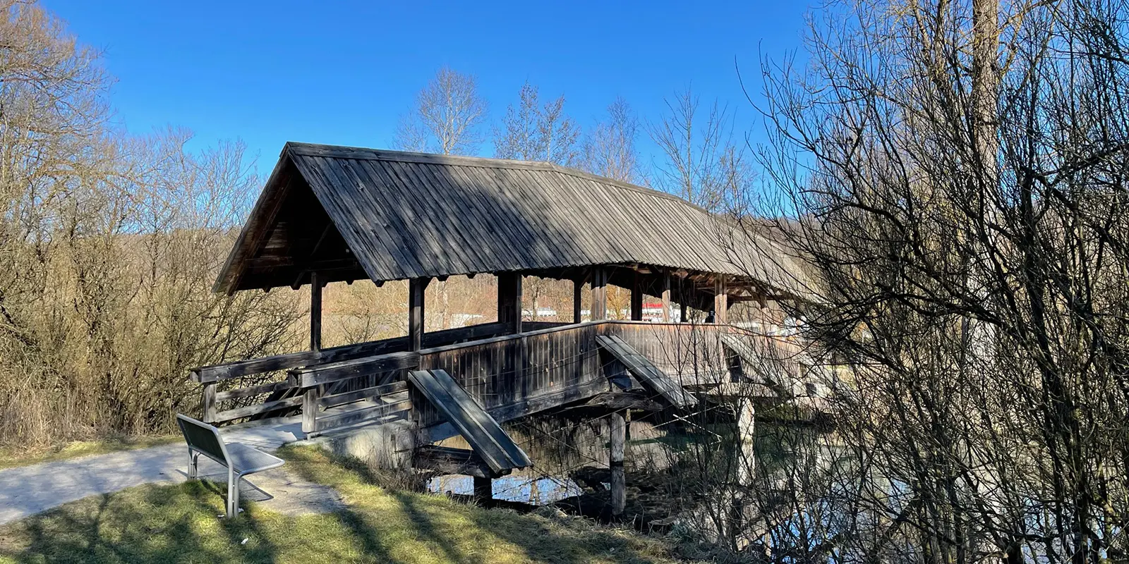 roofed wooden bridge across river