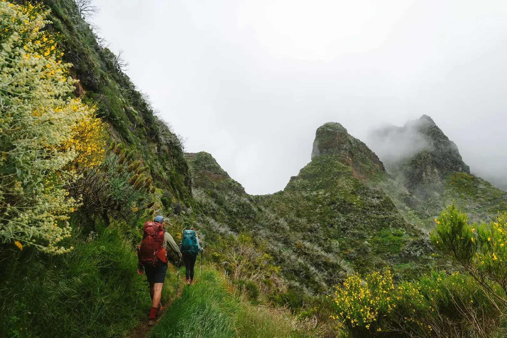 two persons hiking on small mountain path on madeira