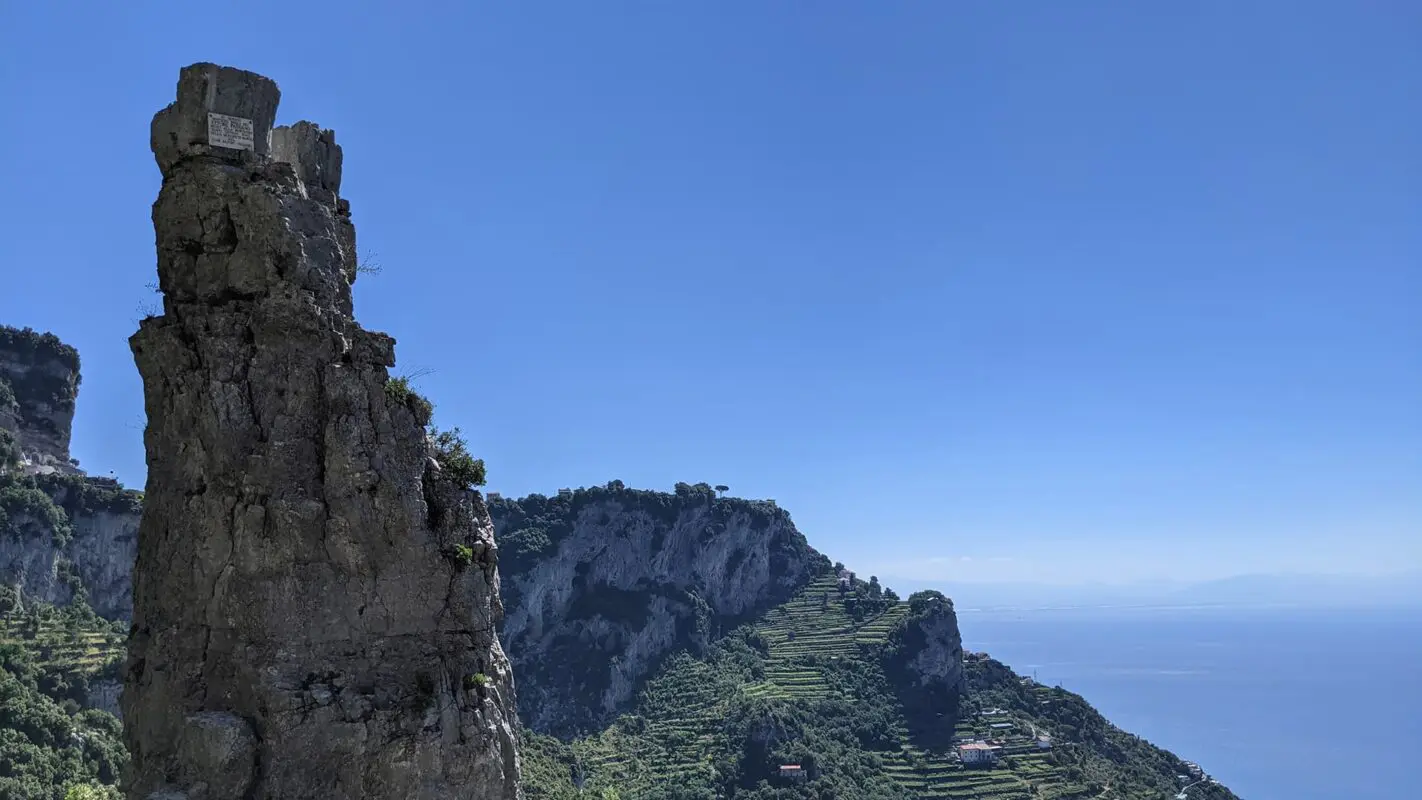 rugged peak with green mountains and ocean in background