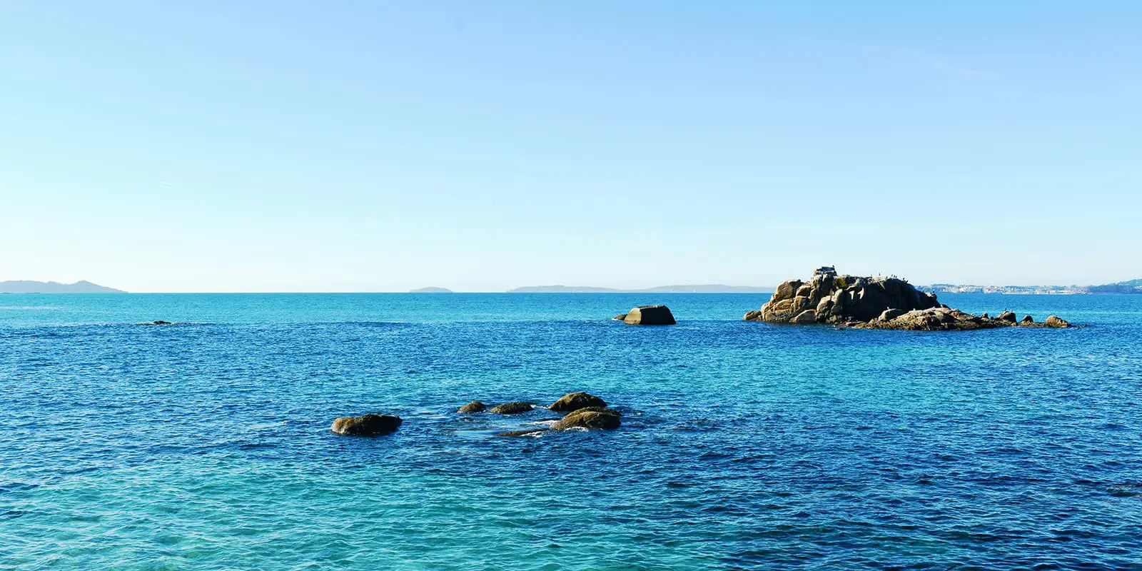 blue ocean with some rocks sticking out