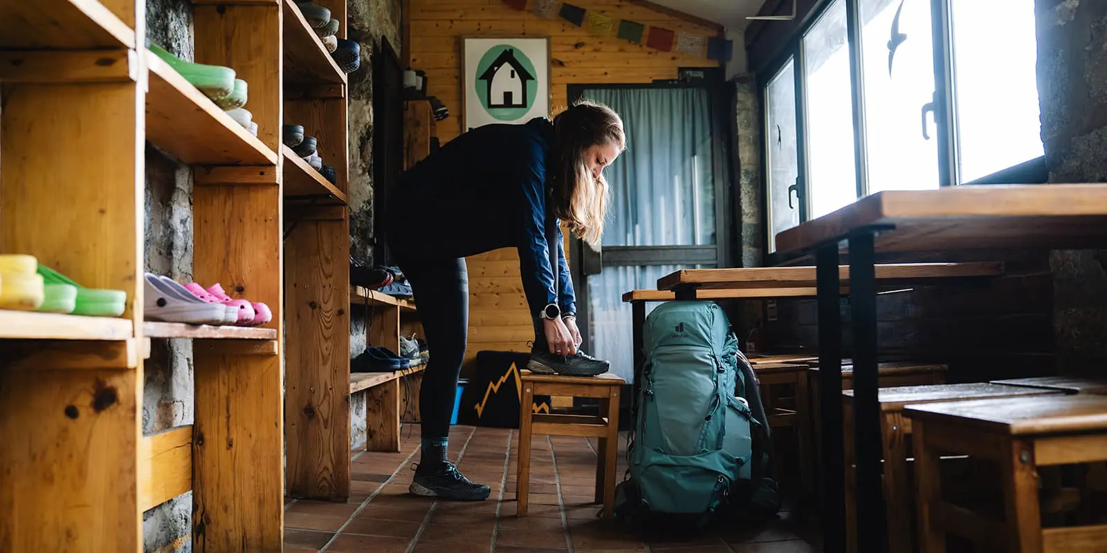 person putting on her hiking shoes in mountain hut