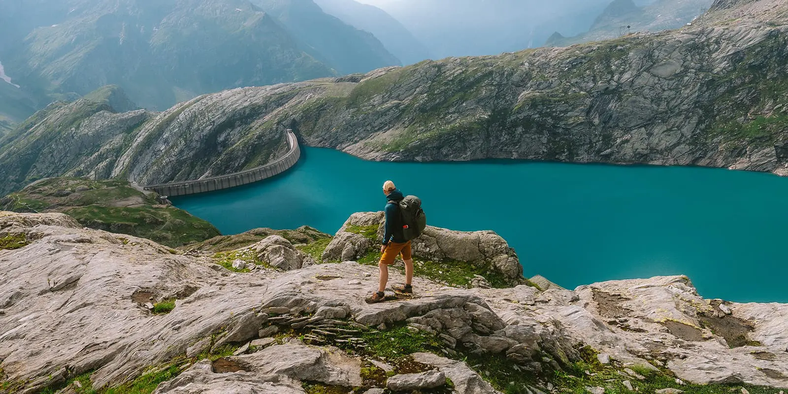 person looking at blue mountain lake