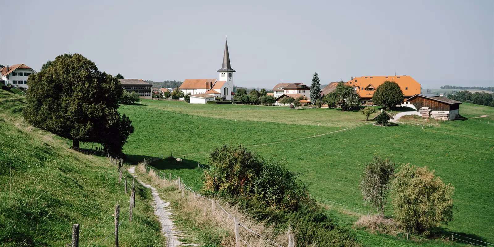 small countryside road leading up to small village