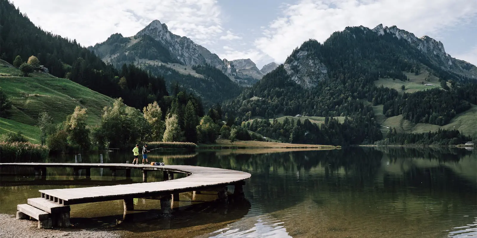 two boys fishing near alpine lake