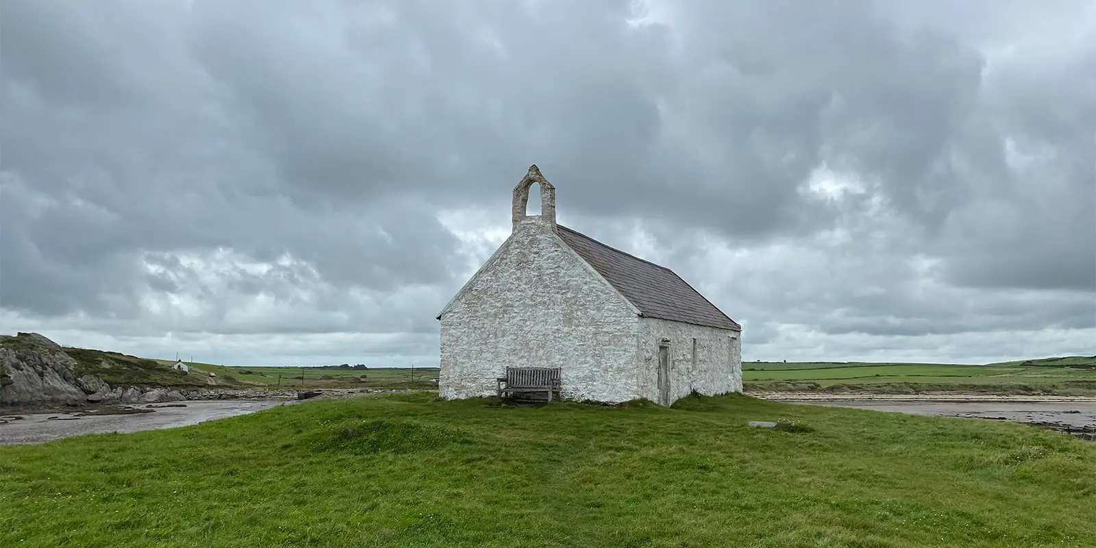 small church on grassy field in Wales