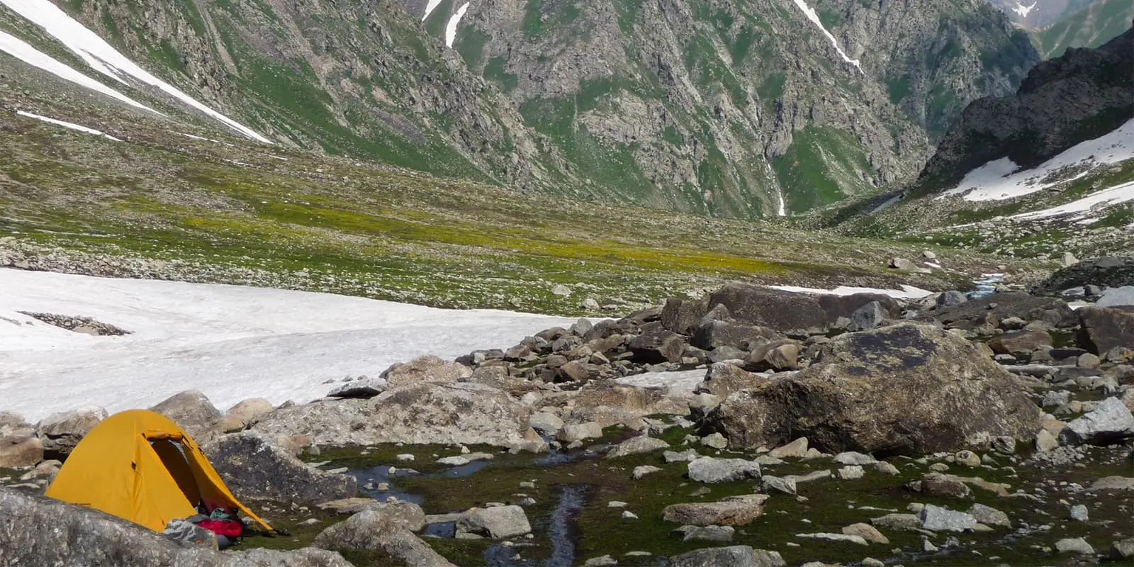 pitched tent near snowfield in the Tajik mountains