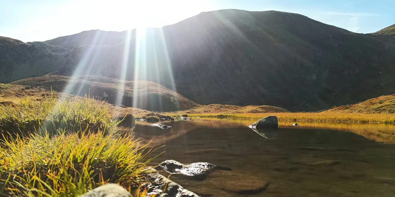 sun shining over mountain lake in the austrian alps