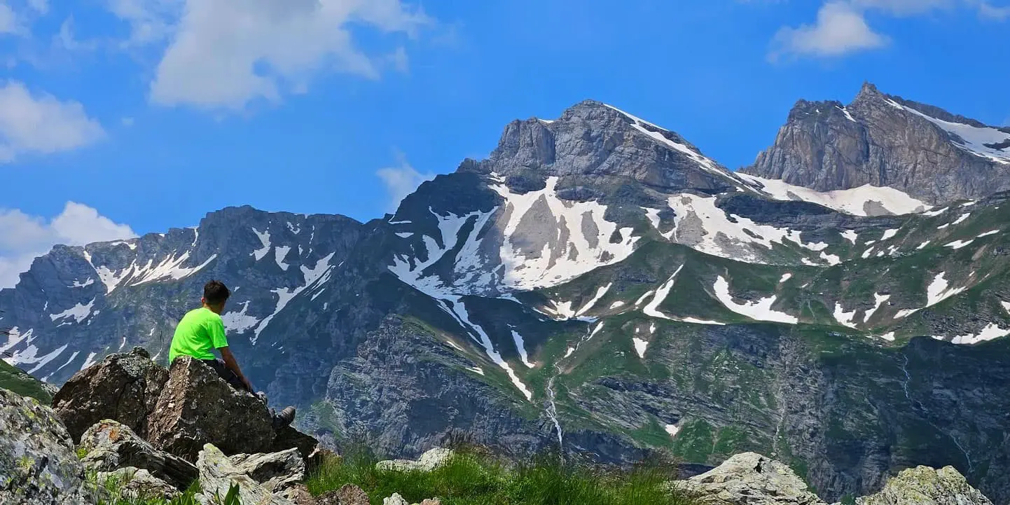 person looking out over snow capped mountain peaks