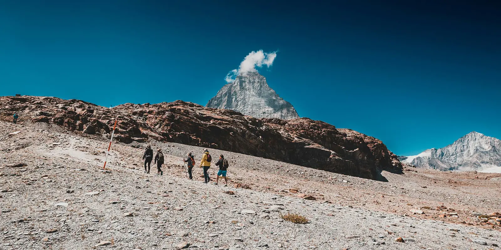 Panoramic view of hikers in front of Alp summits at Zermatt, Switzerland.